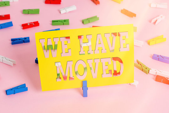 Text sign showing We Have Moved. Business photo text To go from one residence or location to another Relocate Colored clothespin papers empty reminder pink floor background office pin - Powered by Adobe