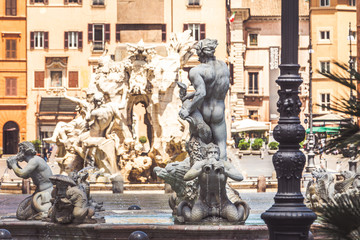 Obraz premium Statues of the fountains of Piazza Navona in the historic center of Rome in Italy. Fontana del Moro in the foreground and Fontana dei Quattro Fiumi in the distance.