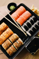 Freshly cooked sushi chef, delicious big rolls with avocado, cheese, salmon, sesame seeds