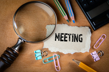  MEETING concept. Magnifying glass, stationery and note paper