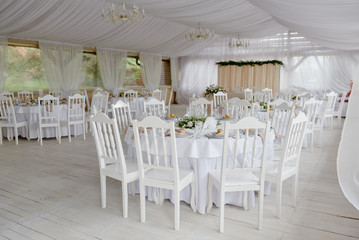 Table setting with blank guest card, plates with napkins and cutlery, copy space. Place setting at wedding reception. Round table served for banquet in restaurant