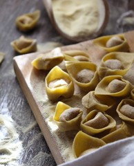 Tortellini bolognesi. Typical italian pasta, filled with meat. Wood table. Vintage mo.od