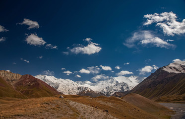 Beautiful mountainious landscape. Snowy mountain peaks. Hilly valley.