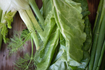 Closeup 4k footage of lots of fresh green vegetables against wooden background. Concept of healthy nutrition and organic food. Perfect background for vegetarian or vegan. Farming and agricultural