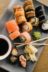 Freshly cooked sushi chef, delicious big rolls with avocado, cheese, salmon, sesame seeds