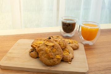 Cookies Corn flakes with coffee and orange juice beside the window in the morning time