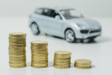 Finance: A stack of coins with out-of-focus car.