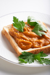 healthy toast with zucchini caviar. Russian traditional sandwich served in a plate with herbs on a white table