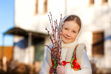 Russian girl in national scarf with branches of a willow in his hands © marinkabear