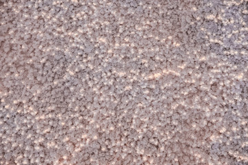 The surface of a pink salt lake covered with salt at sunset. Lovely soft pink texture. Close Up.