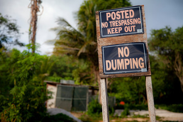 No trespassing, keep out, no dumping sign on a tropical island, horizontal image.