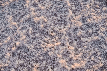 The surface of a pink salt lake covered with salt at sunset. Lovely soft pink texture. Close Up.