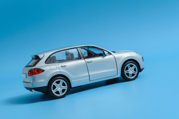 Model toy car, tilted. Blue background.