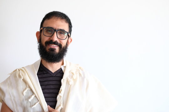 Bearded Jewish with a  Tallit (talis) and Praying. The man is standing in front of a white background