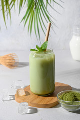 Iced Green matcha latte tea on light white background. Close up.Vertical.