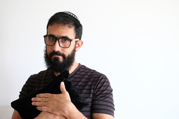 Bearded Jewish holding his Tallit (talis) The man is standing in front of a white background and...