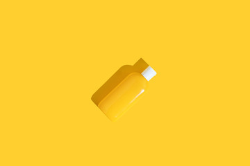 Yellow tube of sunscreen on a bright yellow background with hard shadow. Sun protection in the summer.