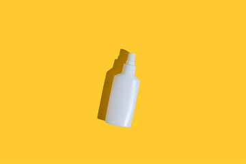 Yellow tube of sunscreen on a bright yellow background with hard shadow. Sun protection in the summer.