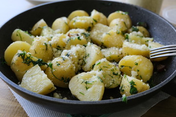 Potatoes with melted cheese and cheese in a pan