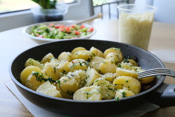 Potatoes with melted cheese and cheese in a pan