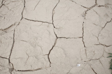 Cracked earth soil ground texture background. Mosaic pattern of dried mud clay earth and sand, top view. The concept of soil erosion climate change and sudden changes in air temperature.