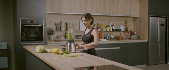 MED Fit female preparing green juice detox cocktail in the kitchen at home. Shot with 2x Anamorphic...