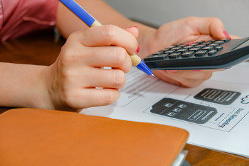 A woman pressed a calculator to calculate income. Family expenses