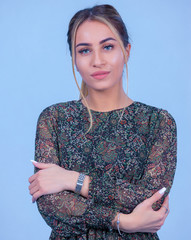 portrait Attractive young blonde model posing in trendy dress isolated at blue studio background. Beautiful girl standing in trendy clothing looking at camera