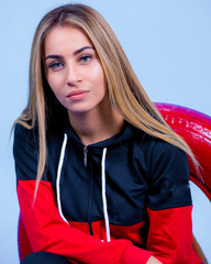 portrait Attractive young blonde pretty young model girl in sportswear posing in blue backround