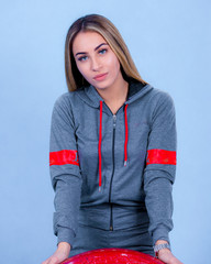 portrait Attractive young blonde pretty young model girl in sportswear posing in blue backround