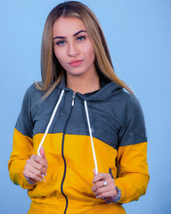 portrait Attractive young blonde pretty young model girl in sportswear posing in blue backround