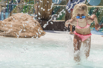 Little girl on water slide at aquapark.