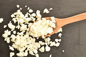 Fresh tasty, nutritious cottage cheese, close-up, on a serving plate of slate.