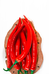 Sharp red chilli perzi lie on a cutting board on a white wooden table