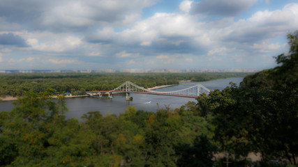 Fototapeta na wymiar A pleasure boat floating on the river. Tilt Shift Effect. Miniature effect. Dnieper River in Kiev.