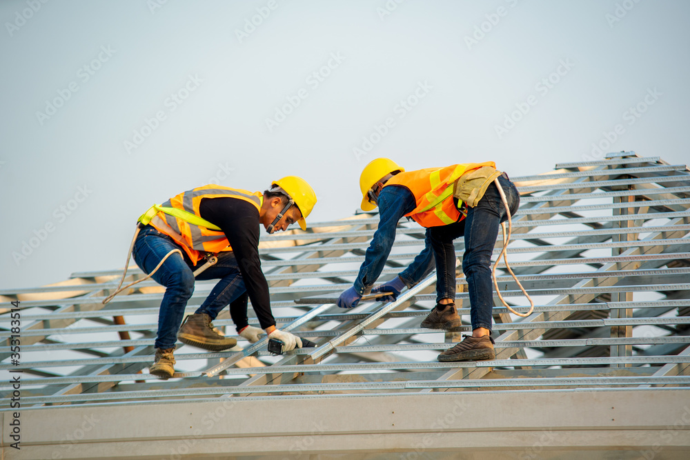Poster handyman working on install the roof,roofer builder working on roof structure of building on constru