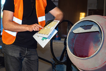 Concrete mixer. Construction. Man stands next to a concrete mixer. Calculation of the required...