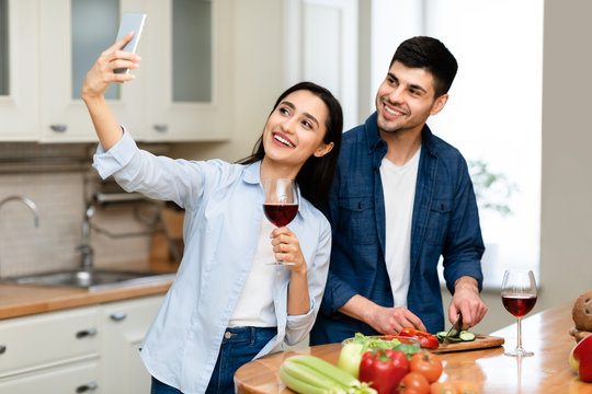 Loving Couple Drinking Wine Together In Kitchen At Home