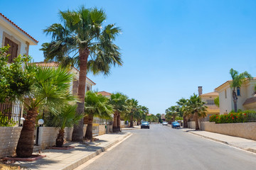 Fototapeta na wymiar Cyprus. Protaras. The resort areas of Cyprus. Apartments near the beach. The streets of Protaras. Palm trees grow along the road. Resort apartments. An island in the Mediterranean. Highway