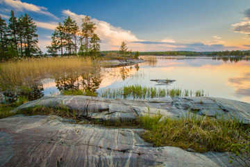 Russia. Ladoga. Karelia. The delightful nature of Karelia. Landscapes of northern nature. Summer morning in Karelia. Reflection of taiga in the water. The coast of Lake Ladoga. Untouched nature.
