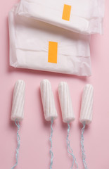 Menstruation in women. Panty liners and tampons on a pink background. Vertical photo