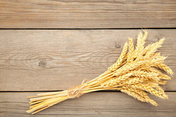 Bunch spikelets of wheat on grey wooden background