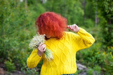 close up red haired dreamy girl with closed eyes posing with bouquet of white flowers in yellow...