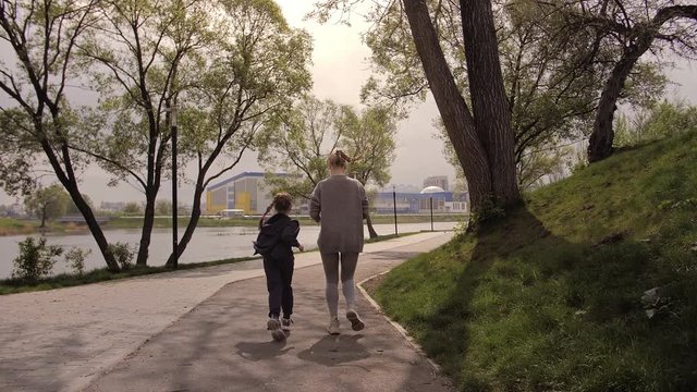 4K Mother and daughter running joggin outdoor in the park