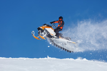 snowmobile rider jumping through snow. RIDER MAN WITH HELMET JUMPING WITH SNOWMOBILE BETWEEN SKY ON...
