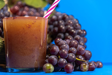 Niagara grape juice and bunches (Vitis labrusca 'Niagara') on blue background