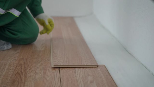 Carpenter laying laminate floor. Laying laminate flooring