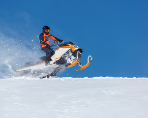 Snowmobile Jump. Extreme Snowmobile Ride & Racing. a bright suit and a snow motorcycle. Winter Recreation. high resolution and photo quality