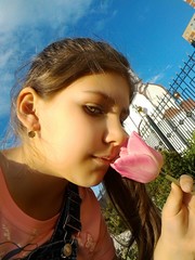 A girl sniffs a flower