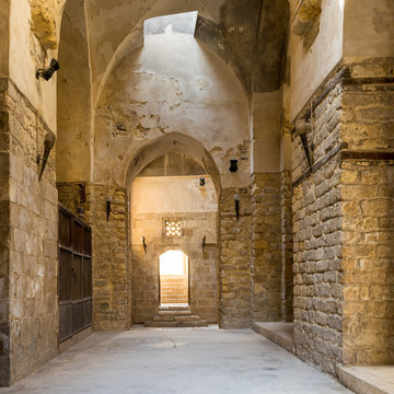 Interior of corridor of ancient building with arched doorways and shabby stone bricks walls
